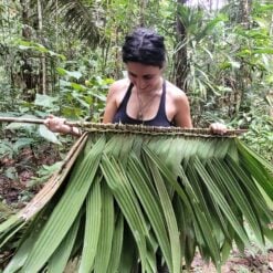 Woman holding woven leaves in the jungle